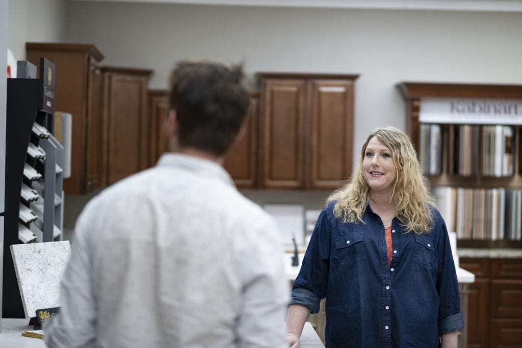 blond woman smiling with kitchen cabinets in the backgroup