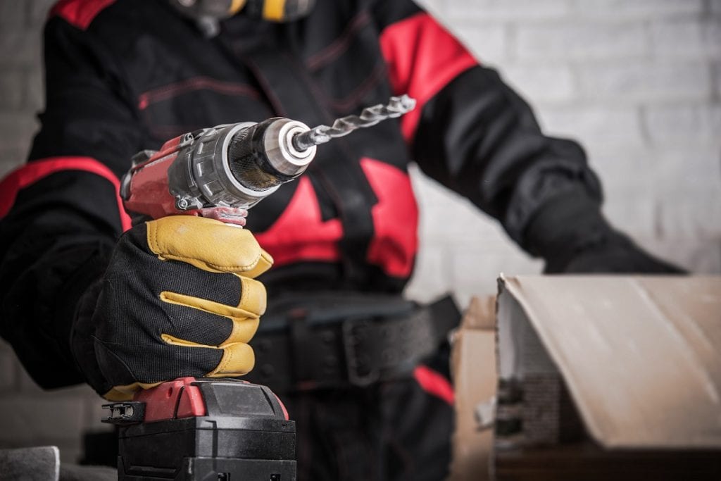 Construction Site Power Drill Tools. Contractor Worker with Powerful Cordless Drill Driver in Hand. Drilling Makes Easy Concept.